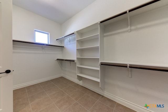 walk in closet with light tile patterned floors