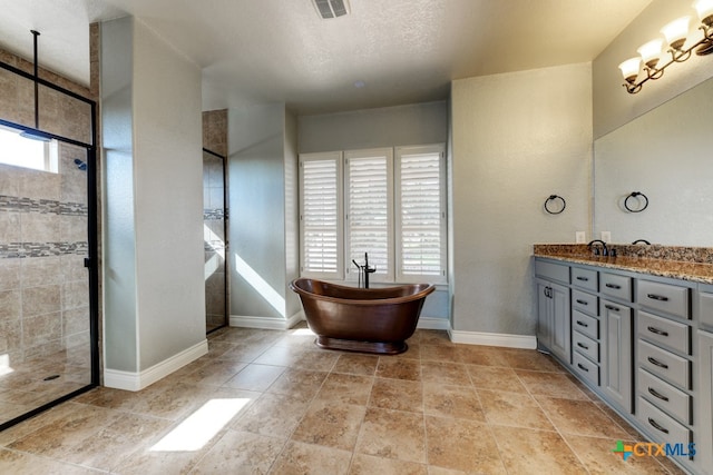 bathroom featuring vanity, a textured ceiling, and separate shower and tub