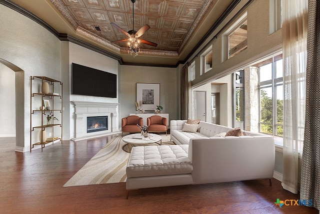 living room with dark wood-type flooring, ceiling fan, and ornamental molding