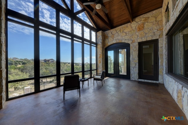 unfurnished sunroom featuring ceiling fan, plenty of natural light, and wood ceiling