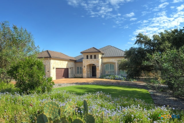 mediterranean / spanish house with a garage and a front lawn