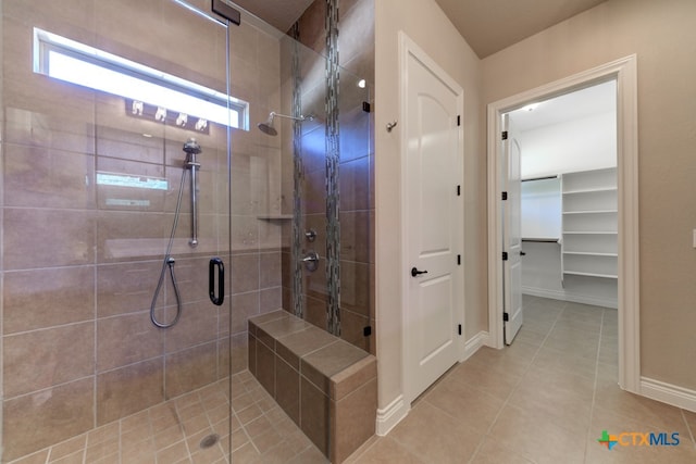 bathroom with a shower with shower door and tile patterned flooring