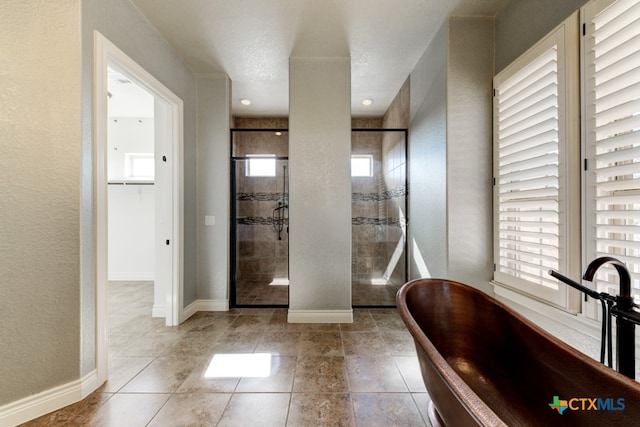 bathroom featuring plus walk in shower, a textured ceiling, and tile patterned floors