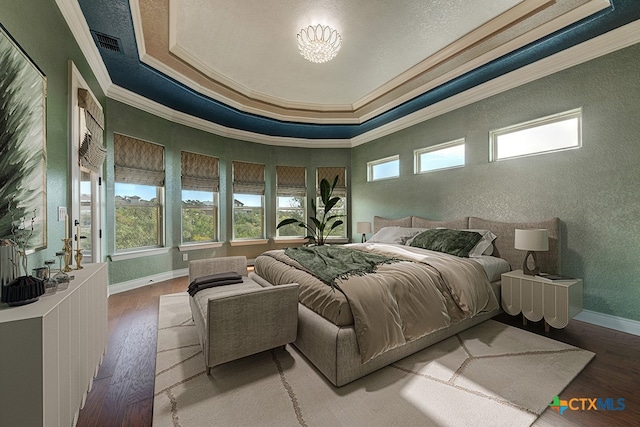 bedroom featuring multiple windows, hardwood / wood-style floors, and ornamental molding