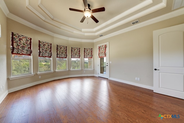 unfurnished room with hardwood / wood-style flooring, ceiling fan, a raised ceiling, and ornamental molding