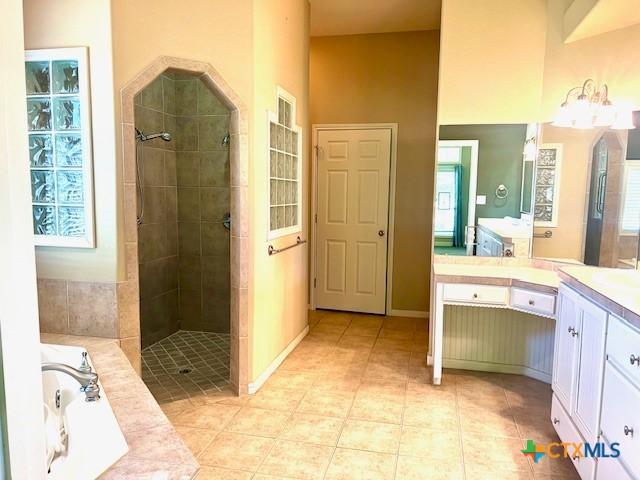 full bathroom with tile patterned floors, vanity, and a stall shower