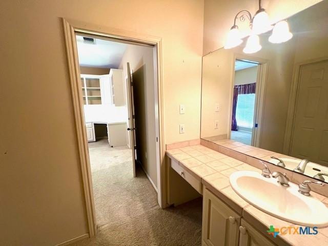 bathroom with vanity, an inviting chandelier, and visible vents