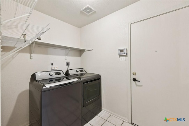 2204 Mikulec Dr, Killeen, TX 76542 - laundry area featuring washing machine and dryer, baseboards, and light tile patterned flooring