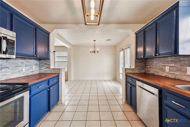 2204 Mikulec Dr, Killeen, TX 76542 - kitchen featuring a chandelier, appliances with stainless steel finishes, wood counters, blue cabinets, and backsplash