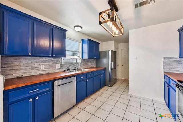 2204 Mikulec Dr, Killeen, TX 76542 - kitchen with wood counters, appliances with stainless steel finishes, blue cabinetry, a sink, and tasteful backsplash