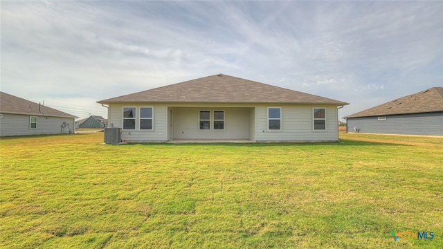 rear view of property featuring a yard, a patio, and cooling unit