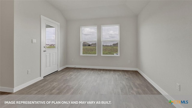 unfurnished room featuring light wood-type flooring and lofted ceiling