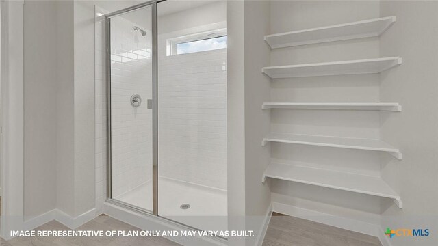 575 Radley Rd, Lockhart, TX 78644 - full bathroom with a shower stall, baseboards, and wood finished floors
