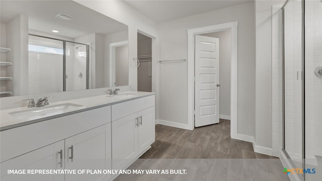 bathroom with vanity, wood-type flooring, and walk in shower