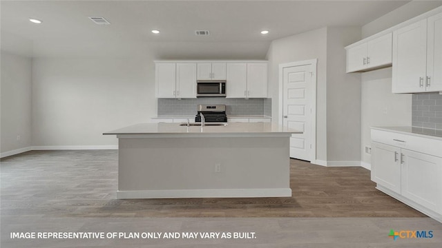 575 Radley Rd, Lockhart, TX 78644 - kitchen with appliances with stainless steel finishes, backsplash, a sink, a kitchen island with sink, and recessed lighting