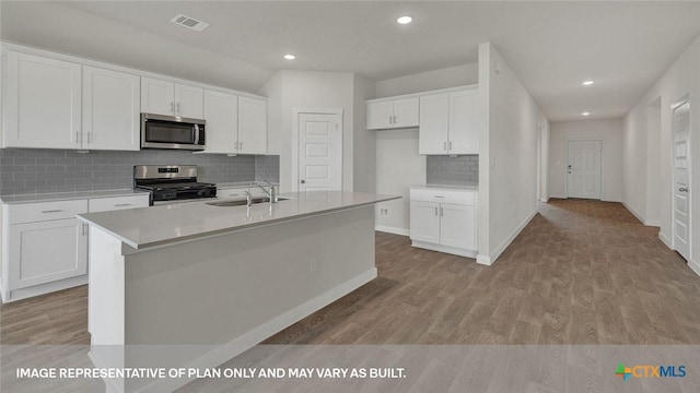 575 Radley Rd, Lockhart, TX 78644 - kitchen with stainless steel appliances, a sink, white cabinets, decorative backsplash, and recessed lighting
