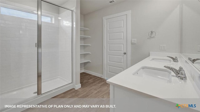 575 Radley Rd, Lockhart, TX 78644 - bathroom with a shower stall, wood finished floors, and double vanity