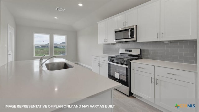 575 Radley Rd, Lockhart, TX 78644 - kitchen featuring stainless steel appliances, a sink, light countertops, backsplash, and recessed lighting