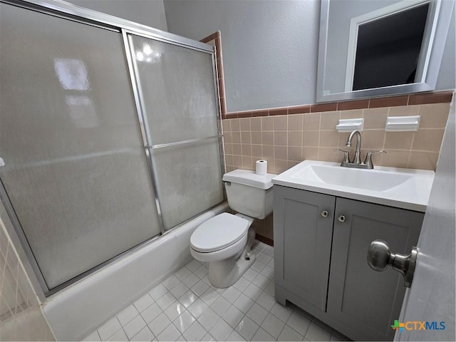 full bathroom with tile patterned flooring, toilet, vanity, and combined bath / shower with glass door