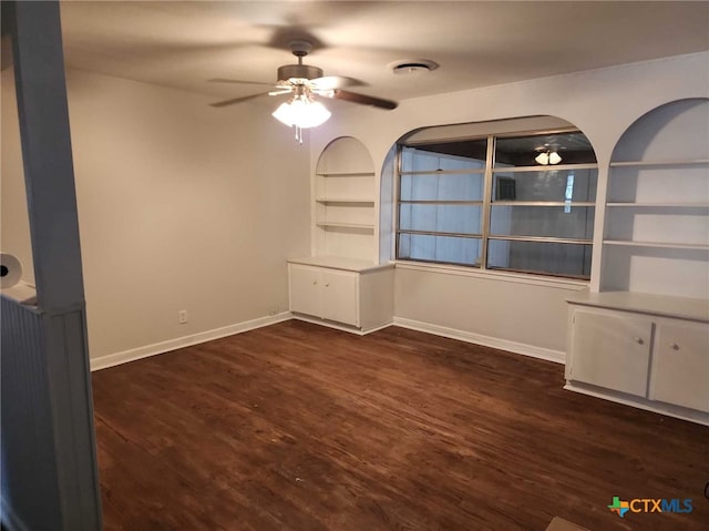 spare room featuring ceiling fan, dark hardwood / wood-style flooring, and built in features