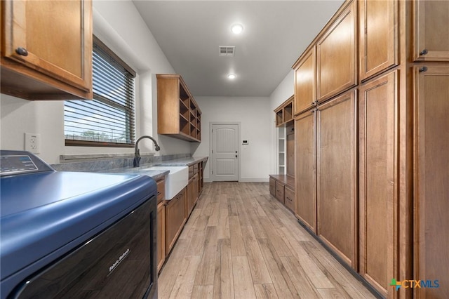 kitchen featuring light hardwood / wood-style floors, sink, and washer / dryer