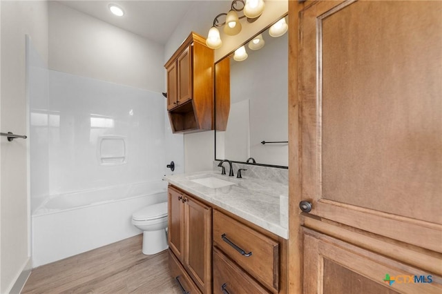 full bathroom with toilet,  shower combination, hardwood / wood-style flooring, and vanity