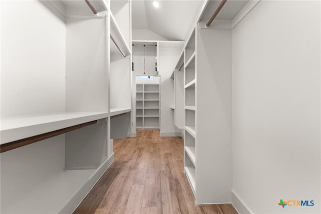 spacious closet with lofted ceiling and light hardwood / wood-style flooring