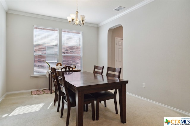 dining area featuring light carpet, an inviting chandelier, and crown molding