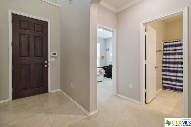 carpeted entryway featuring ornamental molding