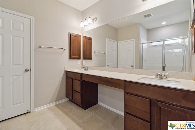 bathroom featuring tile patterned flooring, vanity, and a shower with door