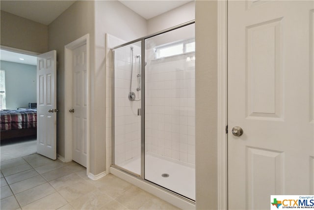 bathroom featuring walk in shower and tile patterned flooring