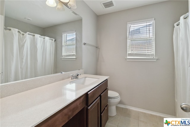 bathroom with toilet, vanity, tile patterned floors, and a healthy amount of sunlight