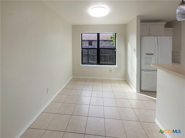 unfurnished dining area featuring light tile patterned floors