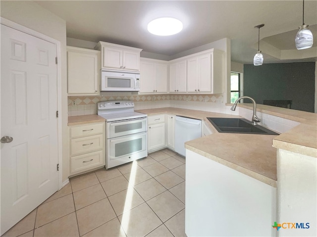 kitchen with white cabinetry, sink, kitchen peninsula, hanging light fixtures, and white appliances