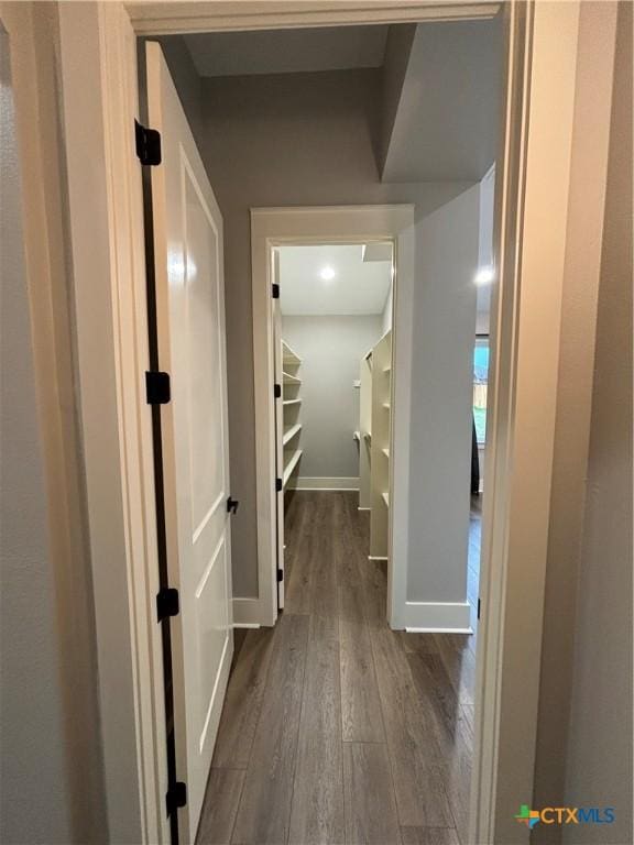 hallway featuring baseboards and dark wood-style flooring