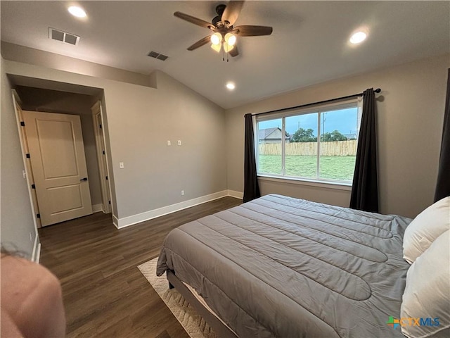 bedroom with dark wood finished floors, vaulted ceiling, visible vents, and baseboards
