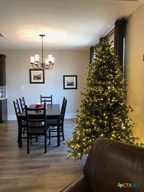 dining area featuring an inviting chandelier, dark wood-type flooring, and baseboards