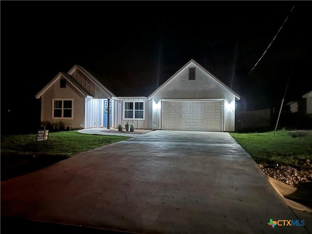 single story home featuring a garage, driveway, and a lawn