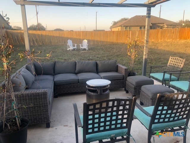 patio terrace at dusk featuring an outdoor living space and a fenced backyard