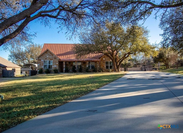 ranch-style home with metal roof, stone siding, a standing seam roof, and a front yard