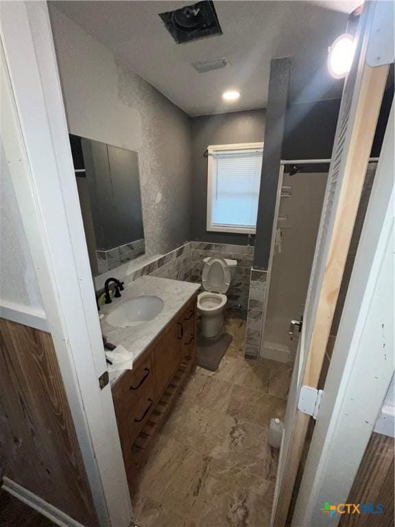 306 Angus St, Victoria, TX 77904 - full bathroom with vanity, tile walls, and a shower stall