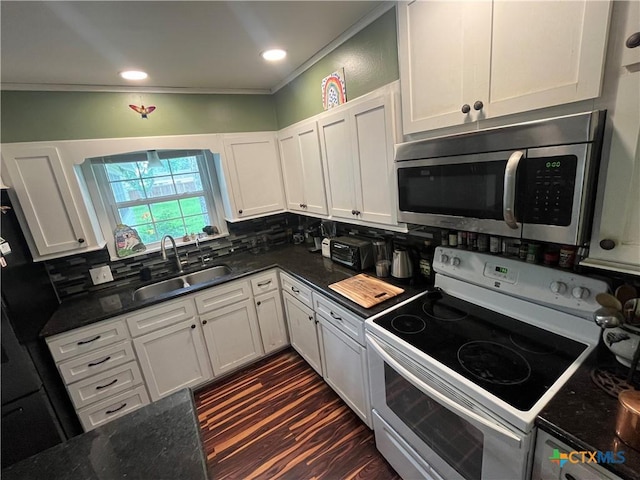 306 Angus St, Victoria, TX 77904 - kitchen featuring white range with electric stovetop, stainless steel microwave, tasteful backsplash, white cabinetry, and dark stone countertops