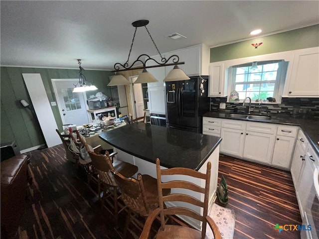 306 Angus St, Victoria, TX 77904 - kitchen with freestanding refrigerator, dark countertops, decorative backsplash, white cabinetry, and ornamental molding