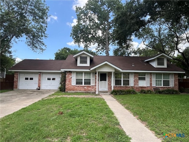 306 Angus St, Victoria, TX 77904 - view of front of property featuring brick siding, a garage, concrete driveway, and a front lawn