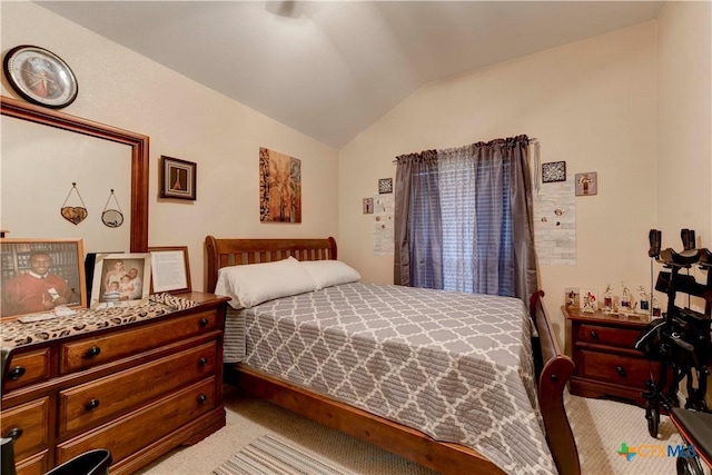 bedroom featuring lofted ceiling and light carpet