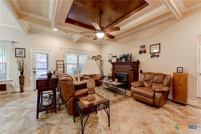 living area featuring crown molding, ceiling fan, a wealth of natural light, and a fireplace