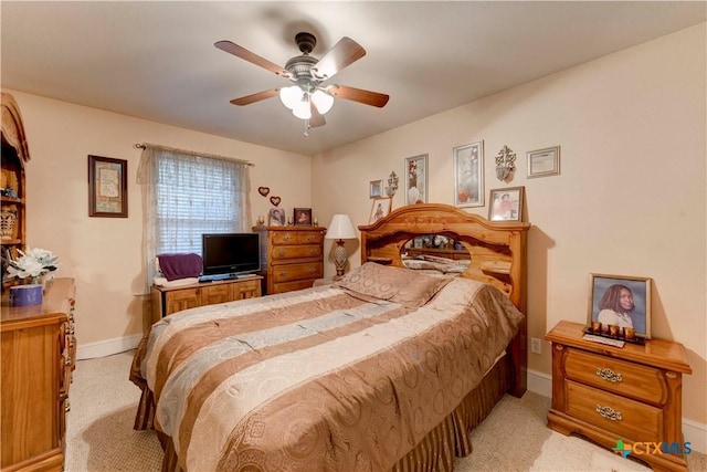bedroom featuring baseboards, light carpet, and a ceiling fan