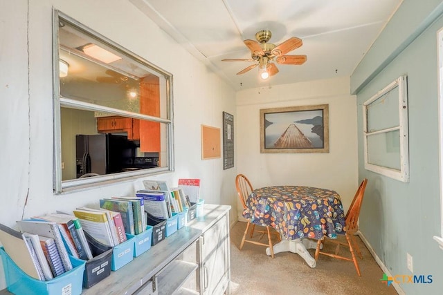 dining space with carpet and ceiling fan