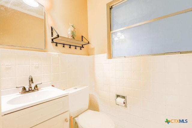 bathroom with vanity, toilet, tile walls, and crown molding