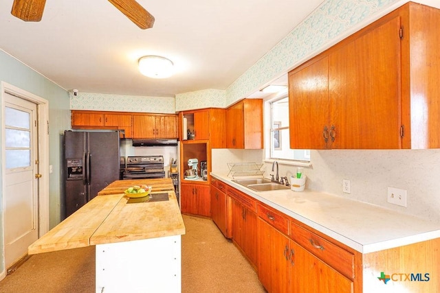 kitchen featuring stainless steel electric stove, a kitchen island, sink, and black refrigerator with ice dispenser